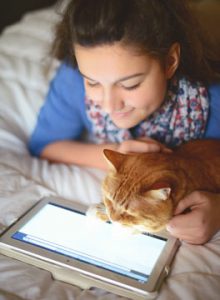 Girl and cat looking at tablet